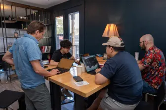 Three at a table, laptops open